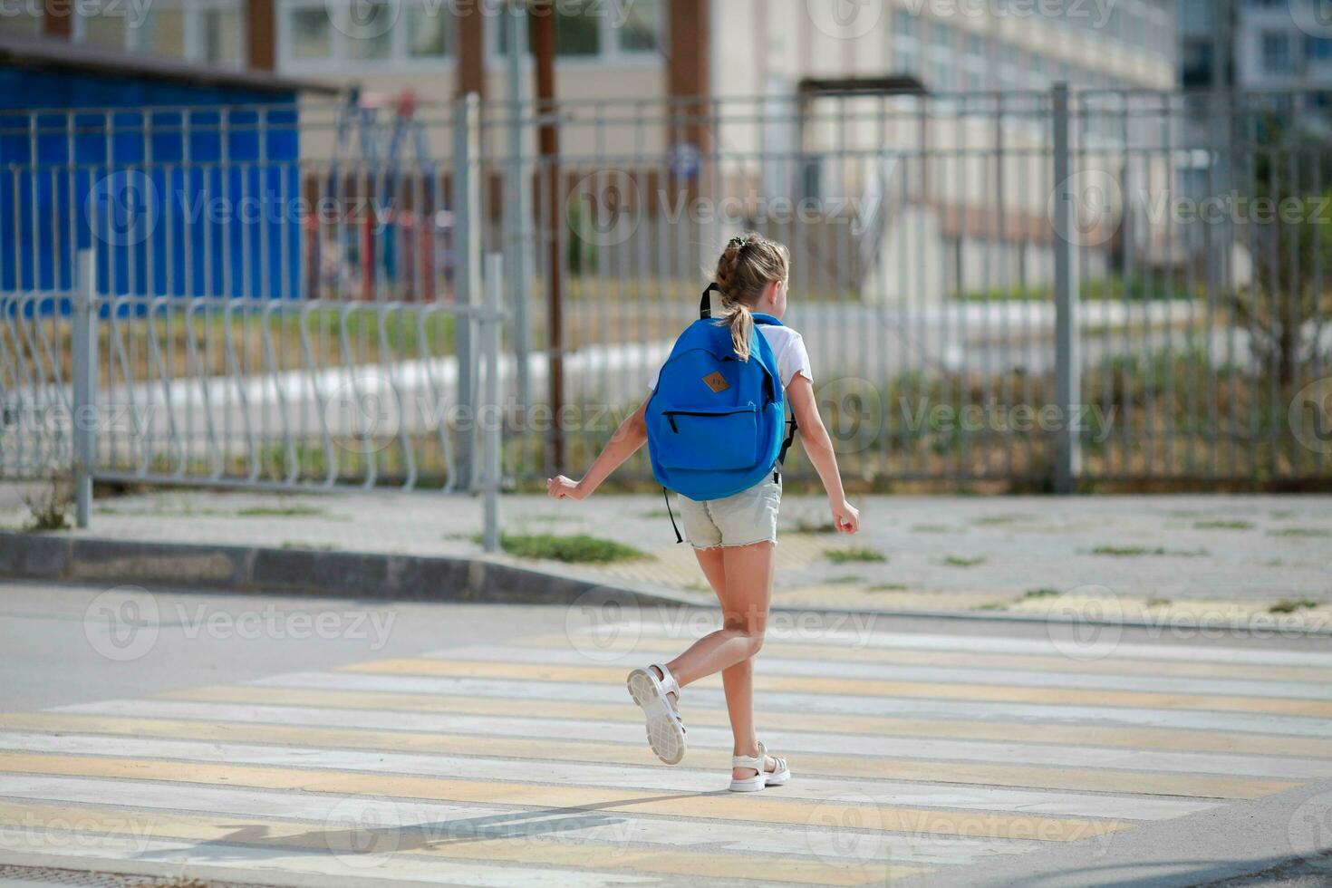 il scolara corre lungo il attraversamento pedonale. il bambino corre lungo il strada per scuola materna e scuola. zebra a piedi nel il città. concetto di pedoni passaggio attraversamento pedonale foto