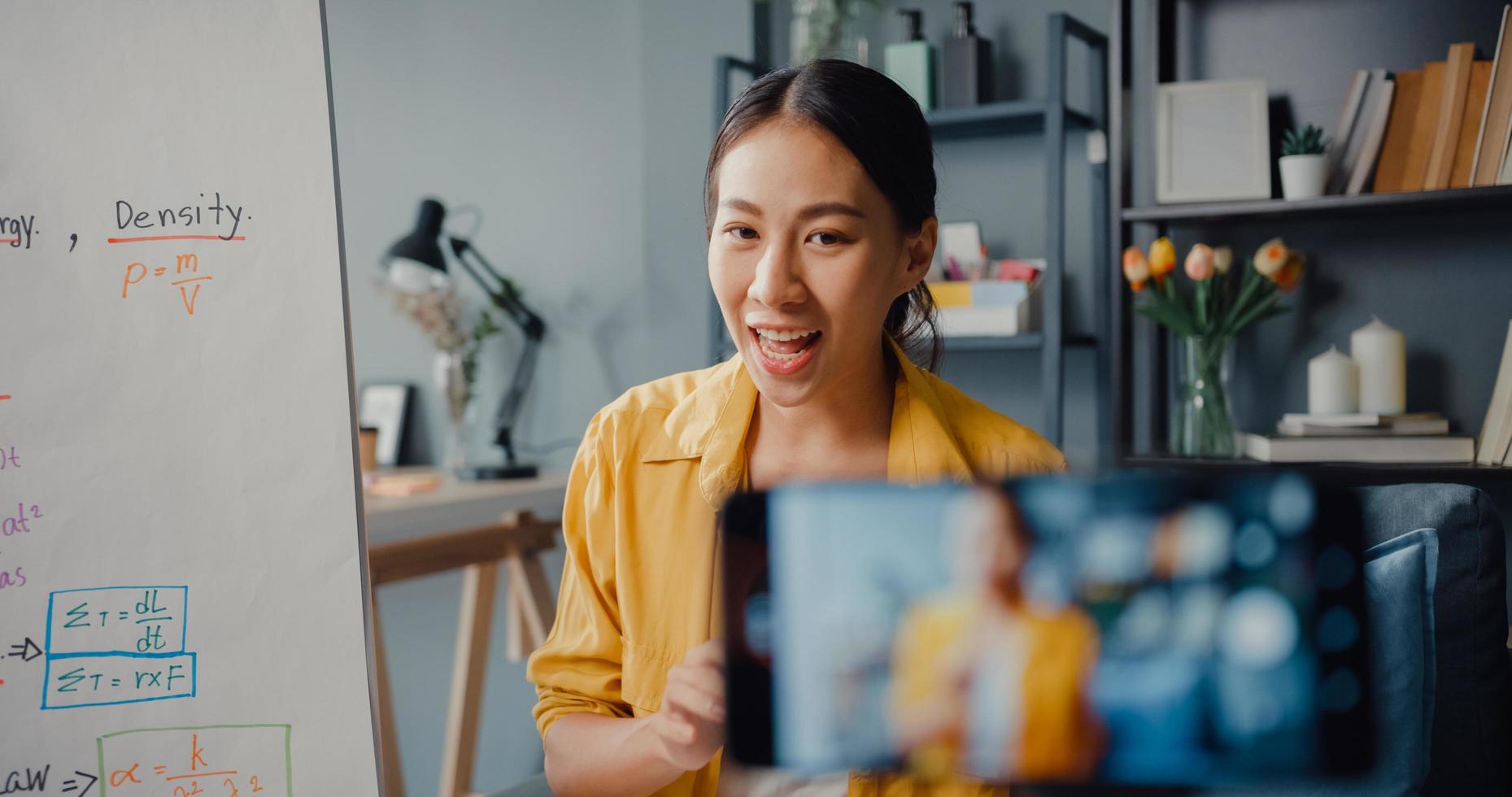 giovane insegnante asiatica in videoconferenza che chiama su smartphone parla tramite webcam impara insegna nella chat online a casa foto
