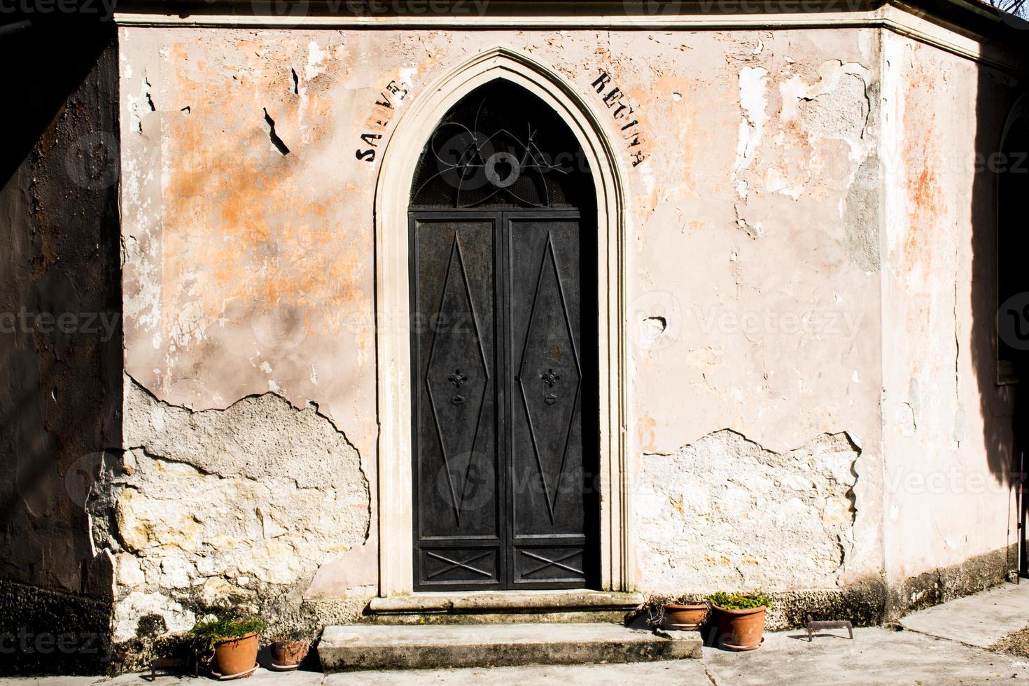 porta in metallo nero con cuore inciso e scritta religiosa foto