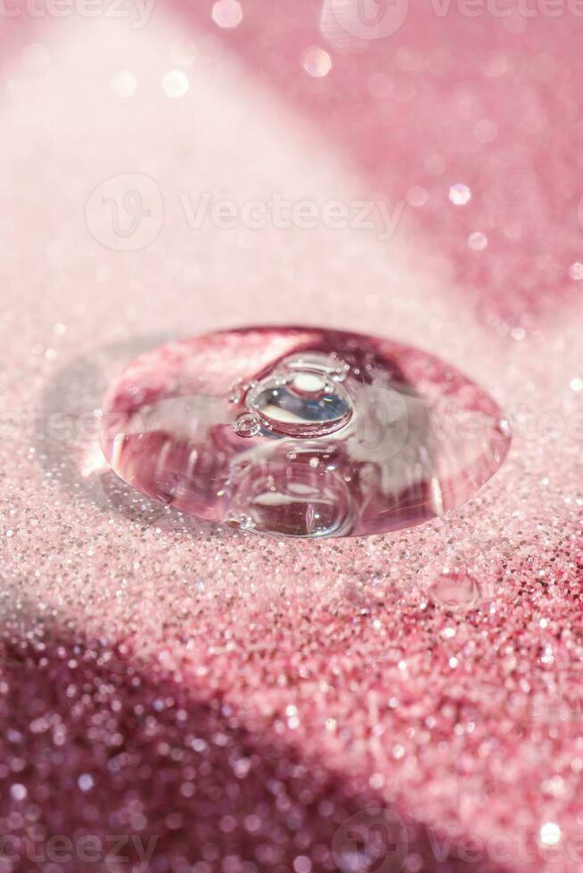 un' far cadere di cosmetico gel su un' rosa splendente sfondo. foto