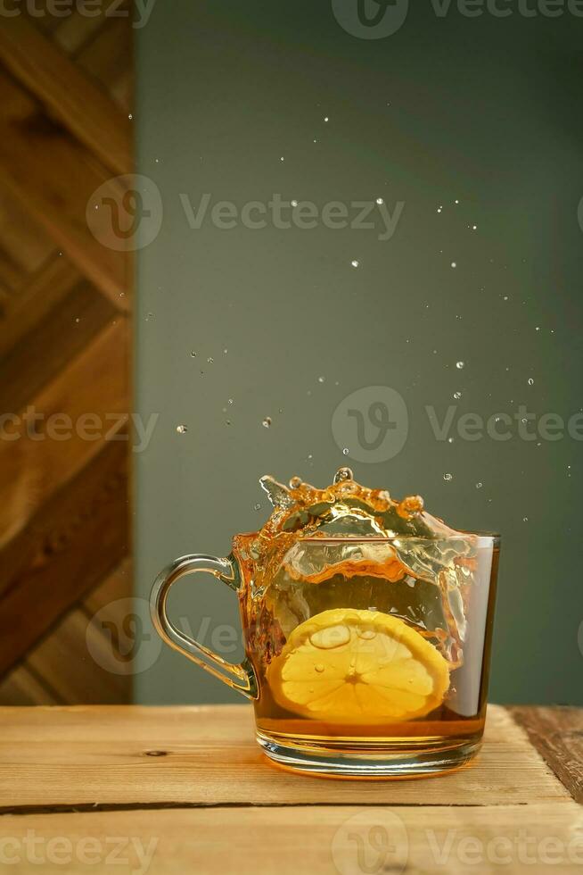 trasparente boccale con tè e spruzzi su un' verde sfondo. foto