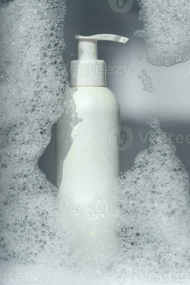 un' bottiglia di gel o shampoo su un' sfondo di bianca schiuma. foto