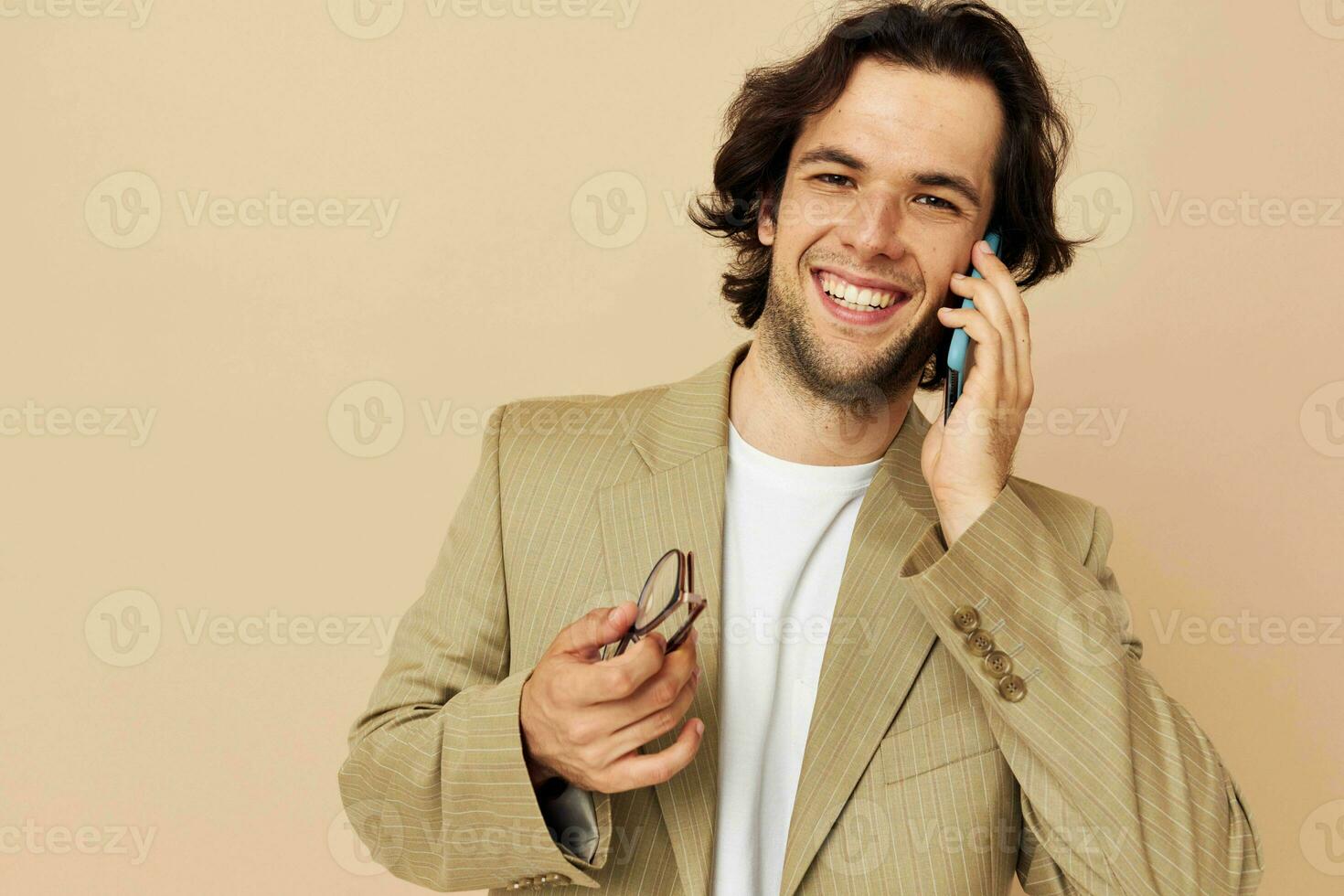 attraente uomo nel un' completo da uomo in posa emozioni parlando su il Telefono stile di vita inalterato foto