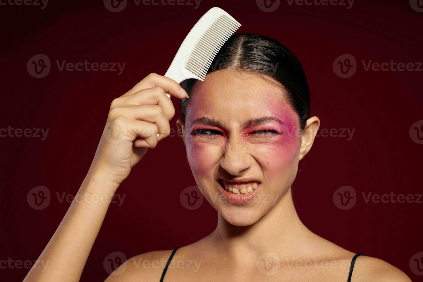 attraente donna con luminosa trucco pettinatura sua capelli personale cura foto