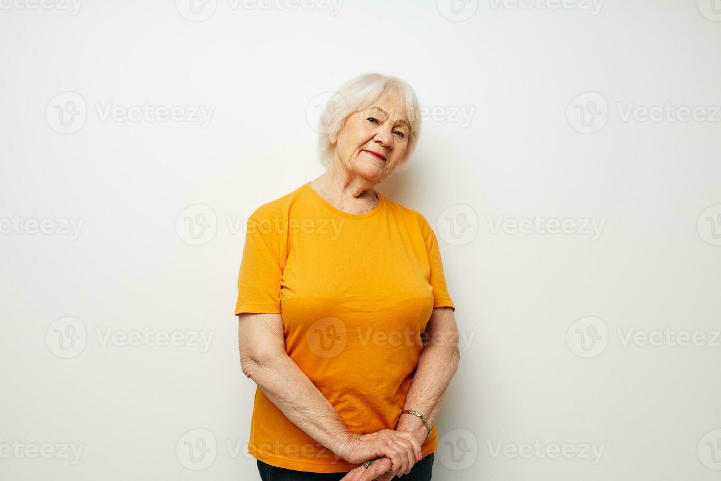 sorridente anziano donna nel un' giallo maglietta in posa avvicinamento emozioni foto