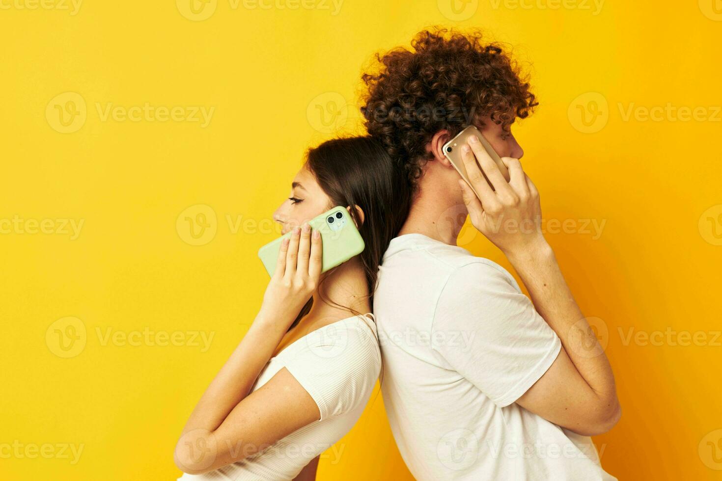 un' tipo e un' ragazza In piedi con loro schiene per ogni altro parlando su il Telefono foto