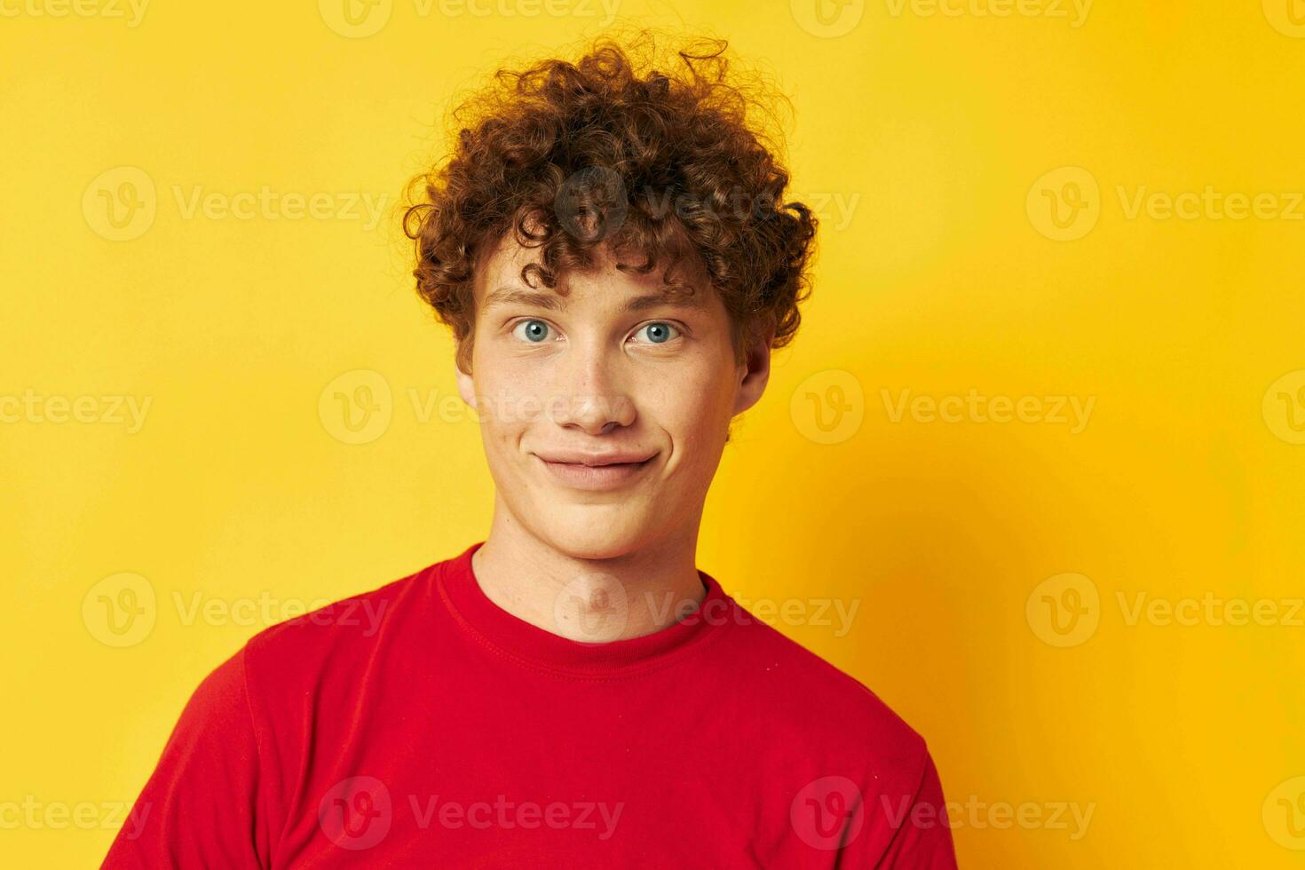 giovane dai capelli ricci uomo rosso t camicia divertimento in posa casuale indossare giallo sfondo inalterato foto