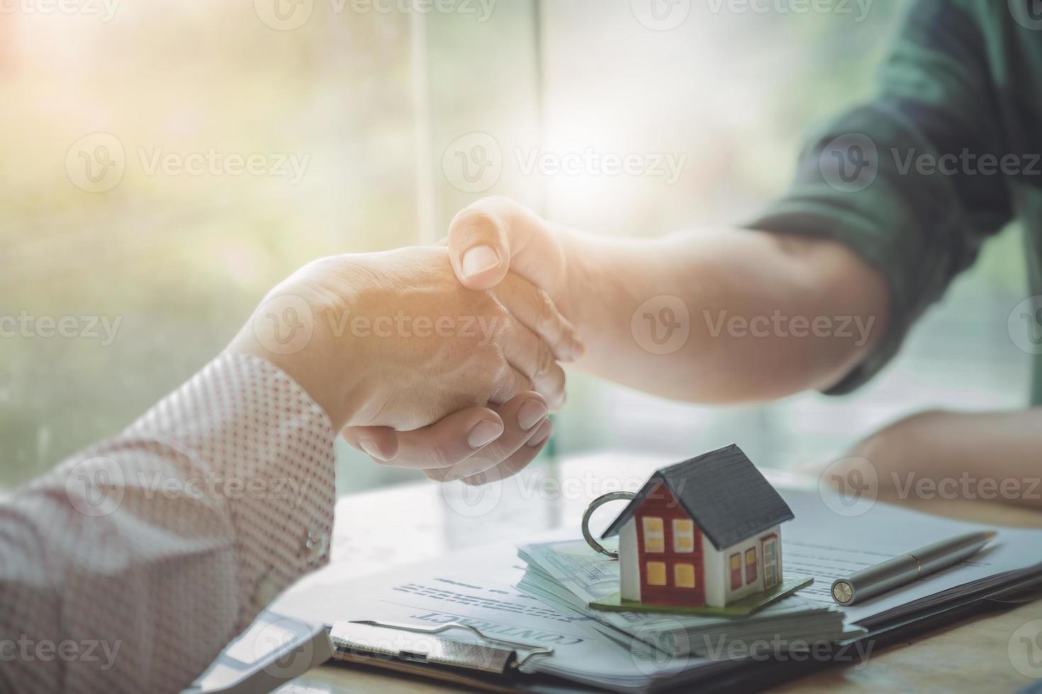 gli agenti immobiliari accettano di acquistare una casa e consegnare le chiavi ai clienti foto