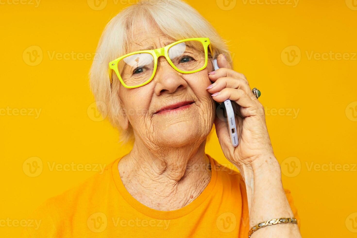 sorridente anziano donna divertimento parlando su il Telefono isolato sfondo foto