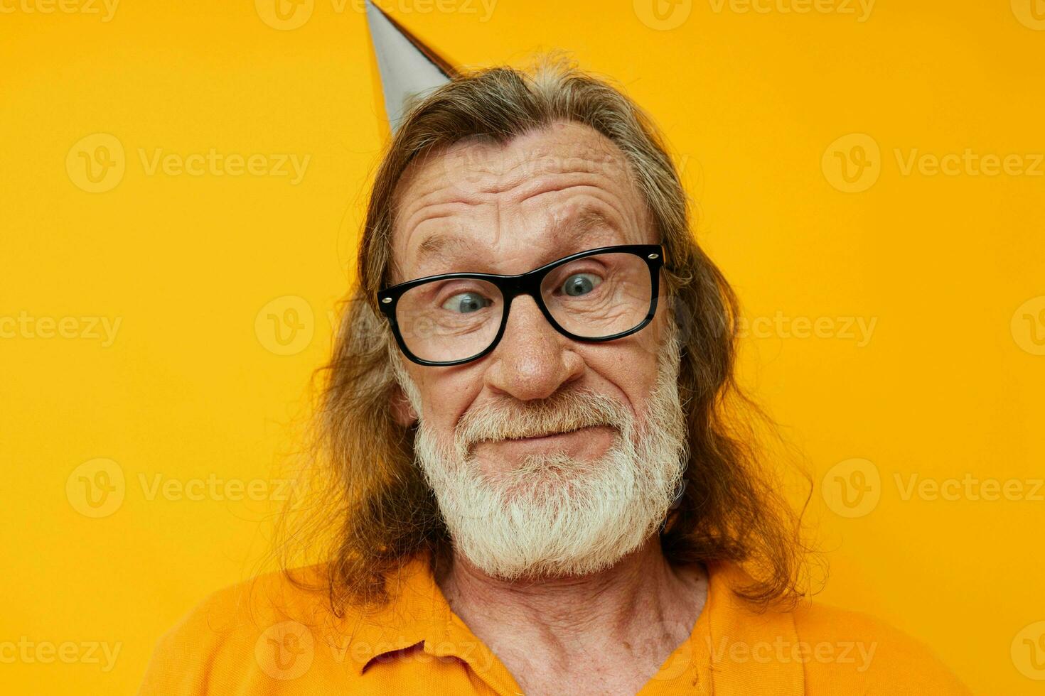 allegro anziano uomo nel bicchieri con un' berretto su il suo testa giallo sfondo foto