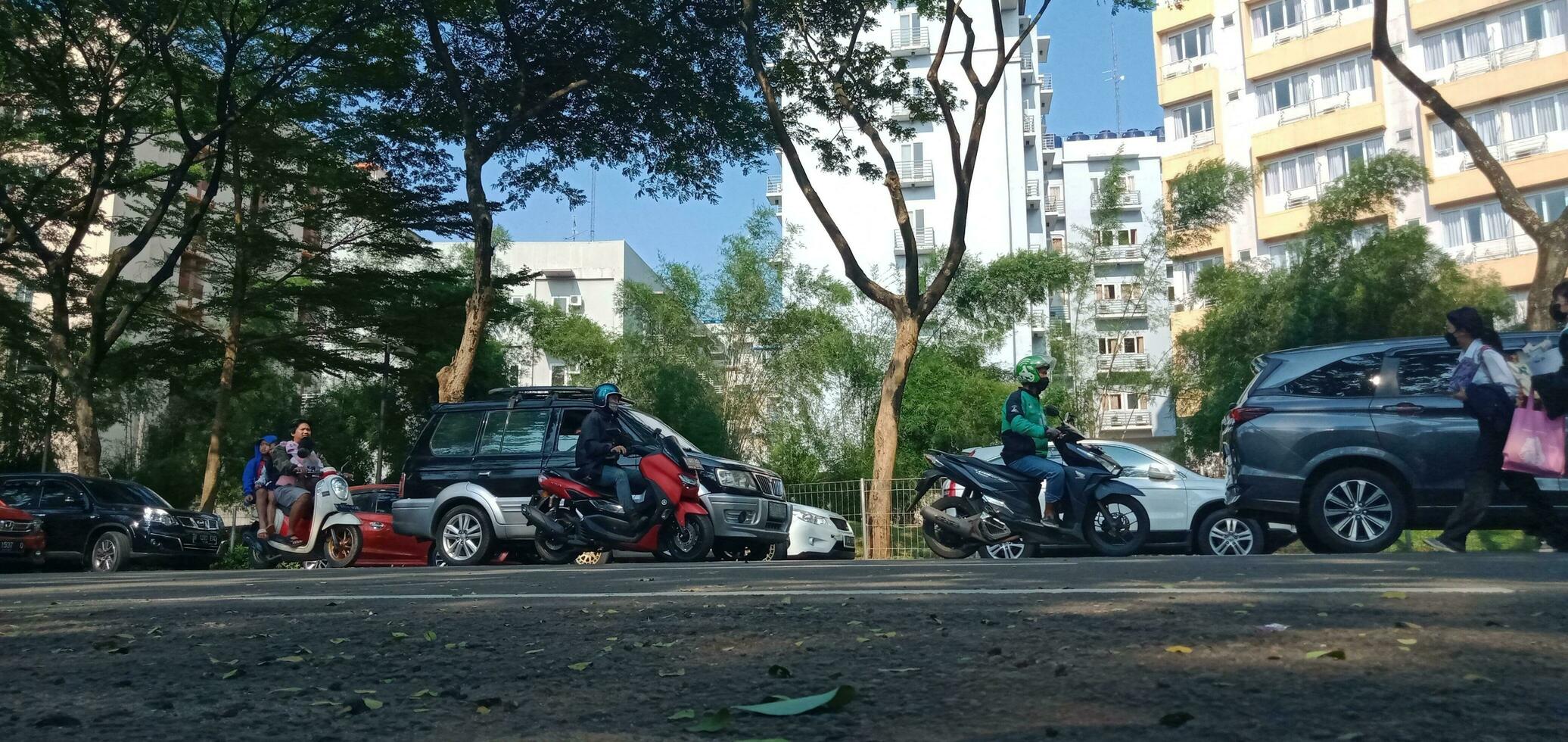 il atmosfera di un' inceppato città strada con un' fondale di lussureggiante edifici e alberi foto