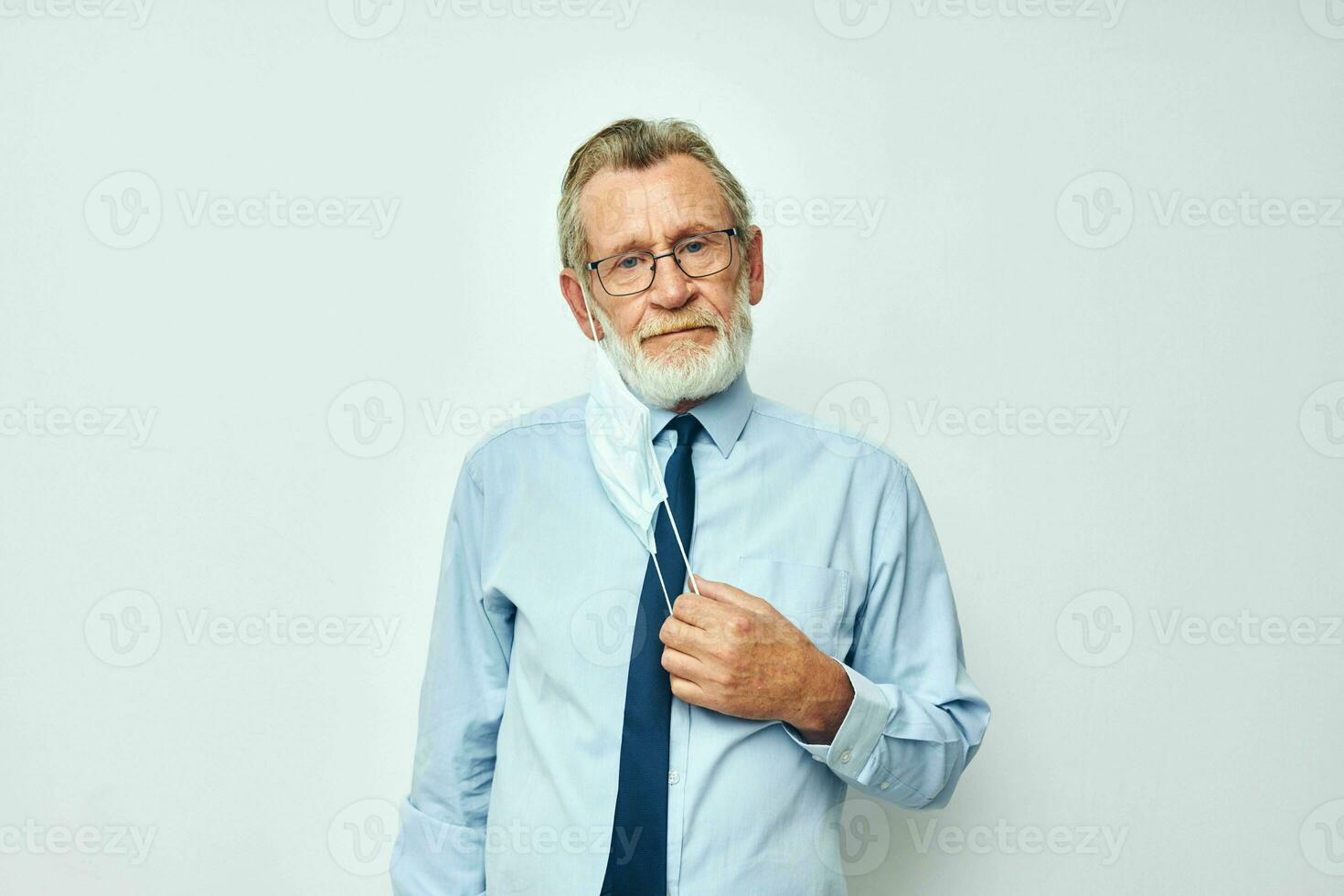 anziano dai capelli grigi uomo nel camicia con cravatta medico maschera sicurezza isolato sfondo foto