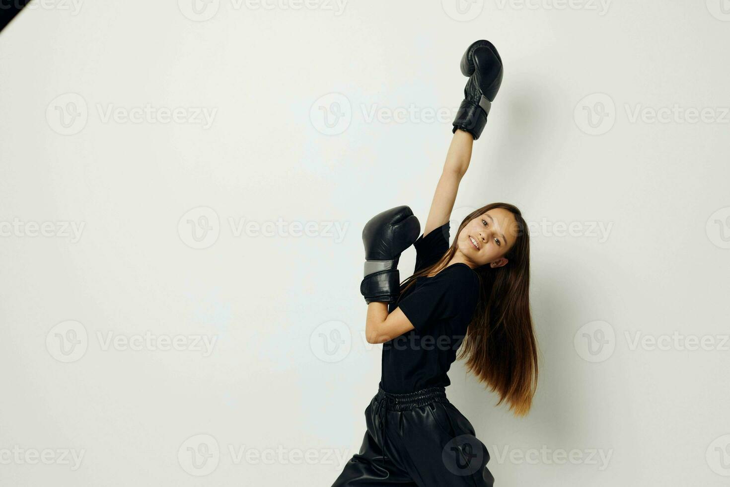 bellissimo ragazza nel boxe guanti punch nel nero pantaloni e un' maglietta fitness formazione foto