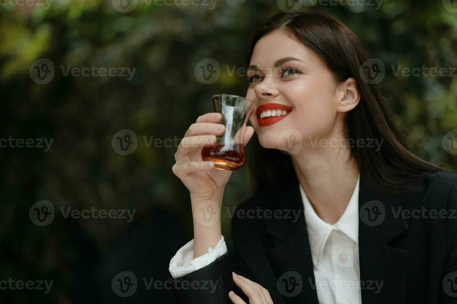 donna Sorridi con denti potabile tè nel un' bar a partire dal un' Turco bicchiere boccale su il strada, primavera viaggiare, città rompere foto