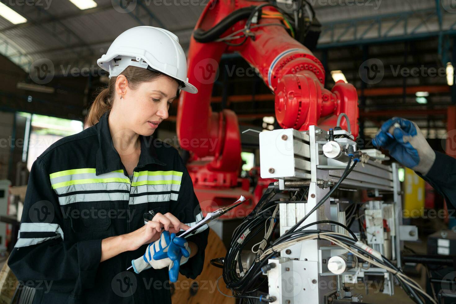 femmina elettrico ingegnere con il missione di installazione un' robot braccio elettrico sistema foto