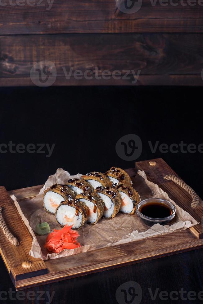 involtini di frutti di mare su un vassoio di legno, bella porzione, sfondo scuro foto