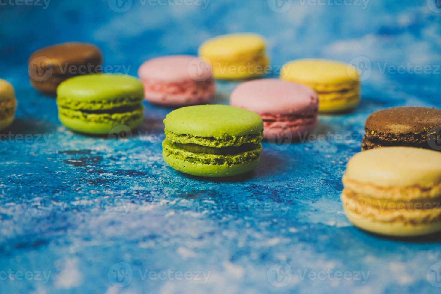 varietà di macarons colorati su sfondo blu foto