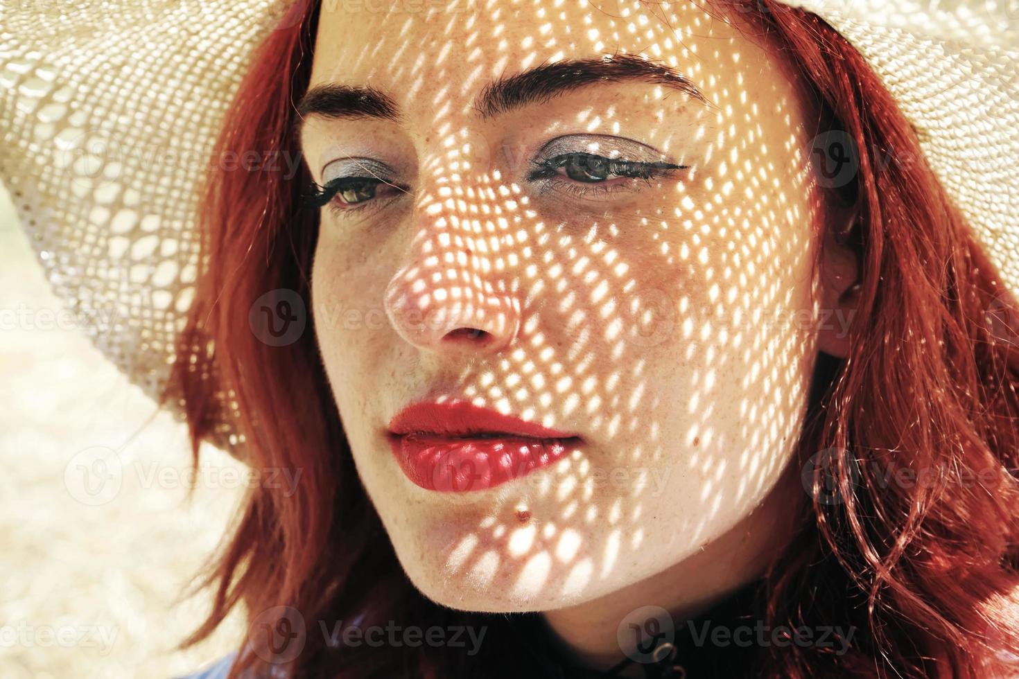 giovane donna dai capelli rossi che copre dal sole foto