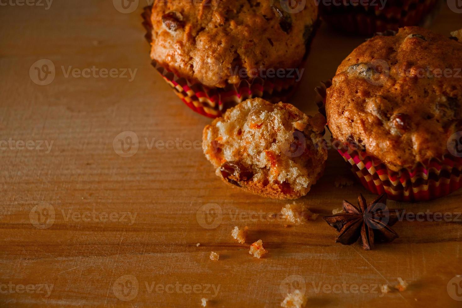 muffin fatti in casa appena sfornati con uvetta e carote pasticcini vegetariani su uno sfondo di legno foto