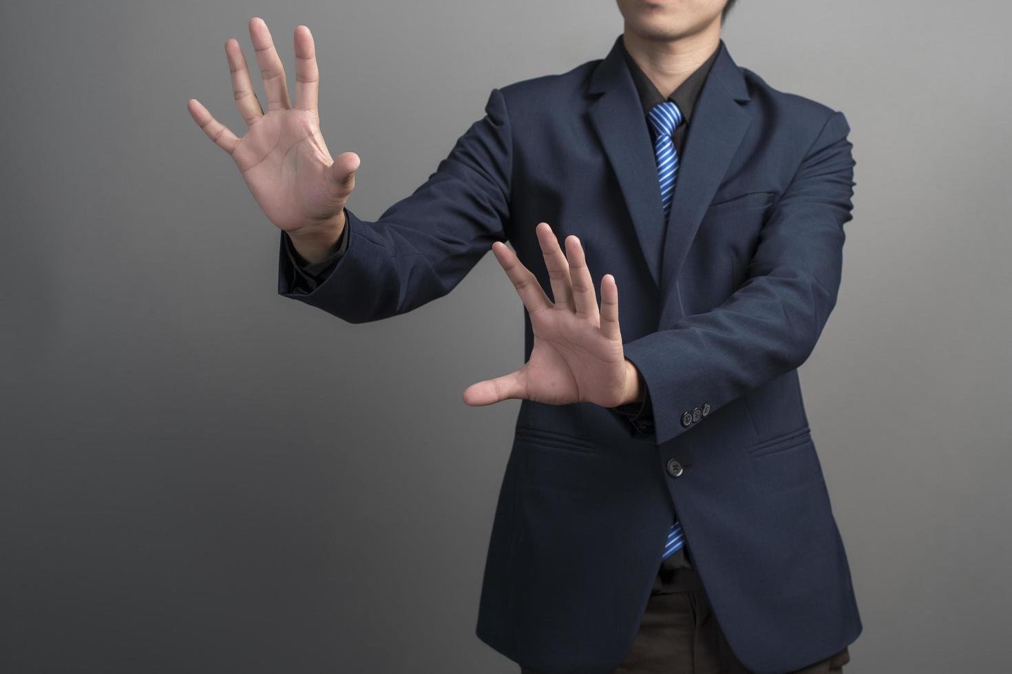 primo piano di uomo d'affari in abito blu che tocca su sfondo grigio foto