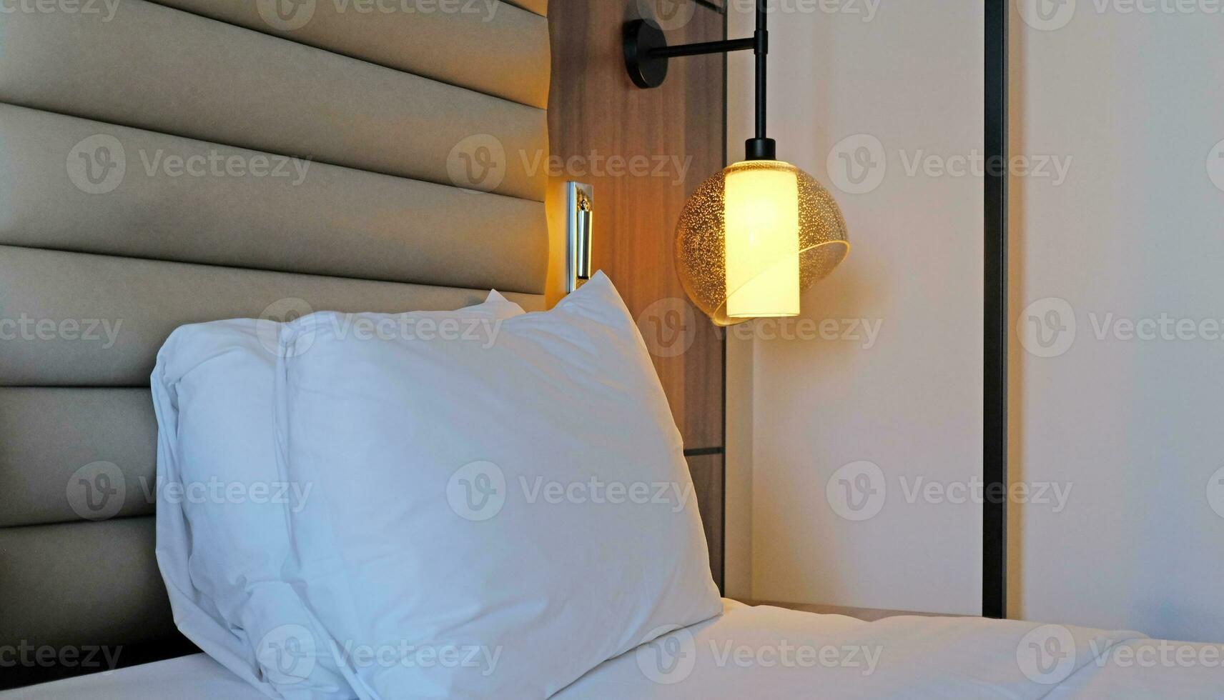 un' frammento di un' Camera da letto con un' moderno accogliente interno design di un' Casa o Hotel. morbido cuscino e lenzuolo, elegante confortevole arredamento. foto