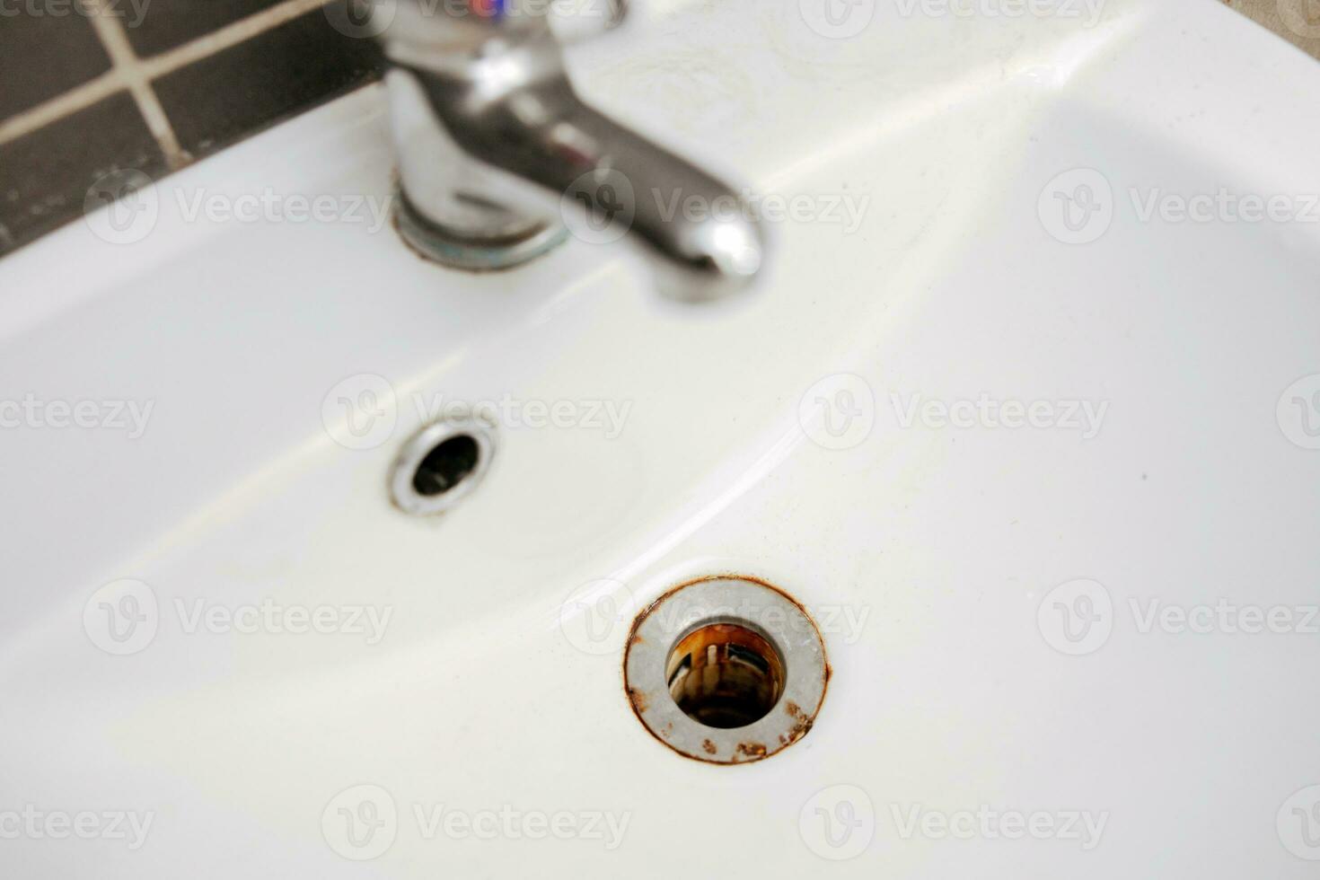 sporco e arrugginito lavabo, vicino su Visualizza. metallo drain buco con rosso ruggine macchia. corrosione, antigenico. macchiato bagno impianto idraulico. pulizia servizio necessario. immondo casa. foto