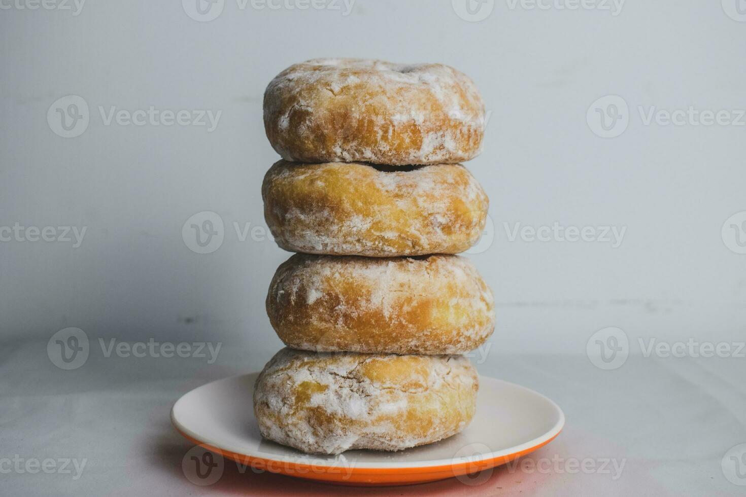 delizioso ciambelle con in polvere zucchero su piatto foto