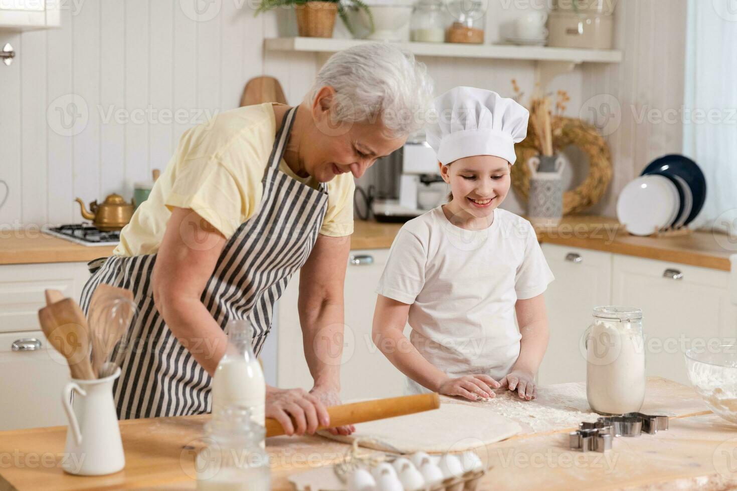 contento famiglia nel cucina. nonna e nipotina bambino cucinare nel cucina insieme. nonna insegnamento ragazzo ragazza rotolo su Impasto infornare biscotti. domestico lavoro di squadra porzione famiglia generazioni concetto. foto