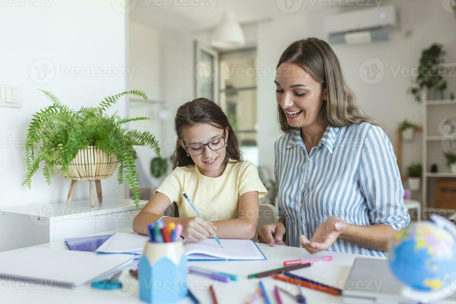 caucasico donna guardare orgoglioso a sua figlia durante homeschooling e fare alcuni la pittura. foto