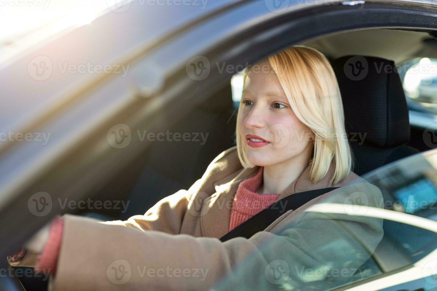 giovane donna seduta nel un' macchina. contento donna guida un' auto e sorridente. ritratto di contento femmina autista timone auto con sicurezza cintura. carino giovane signora contento guida macchina. foto