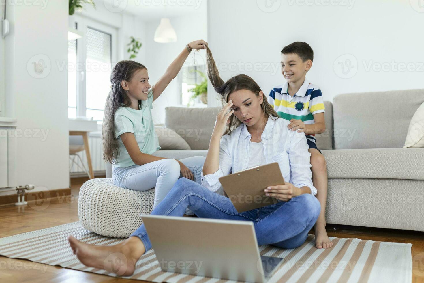 poco cattivo bambini distrarre occupato giovane donna a partire dal opera su il computer portatile a casa foto