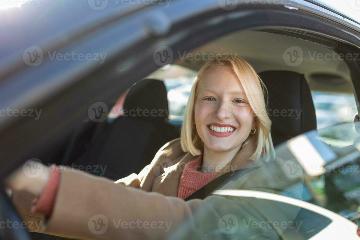 giovane donna seduta nel un' macchina. contento donna guida un' auto e sorridente. ritratto di contento femmina autista timone auto con sicurezza cintura. carino giovane signora contento guida macchina. foto