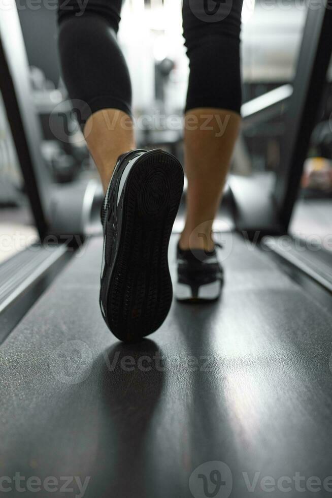 vicino su di suola di scarpe da ginnastica di irriconoscibile atleta jogging su un' tapis roulant. foto