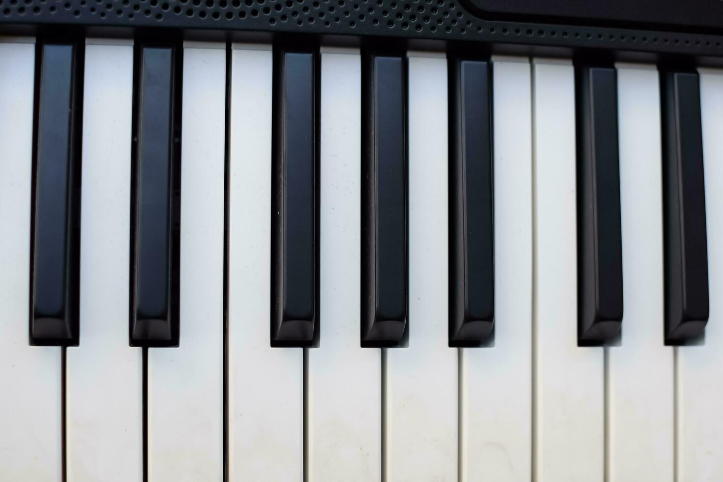 avvicinamento di pianoforte chiavi. pianoforte nero e bianca chiavi e pianoforte tastiera musicale strumento posto a il casa balcone durante soleggiato giorno. foto