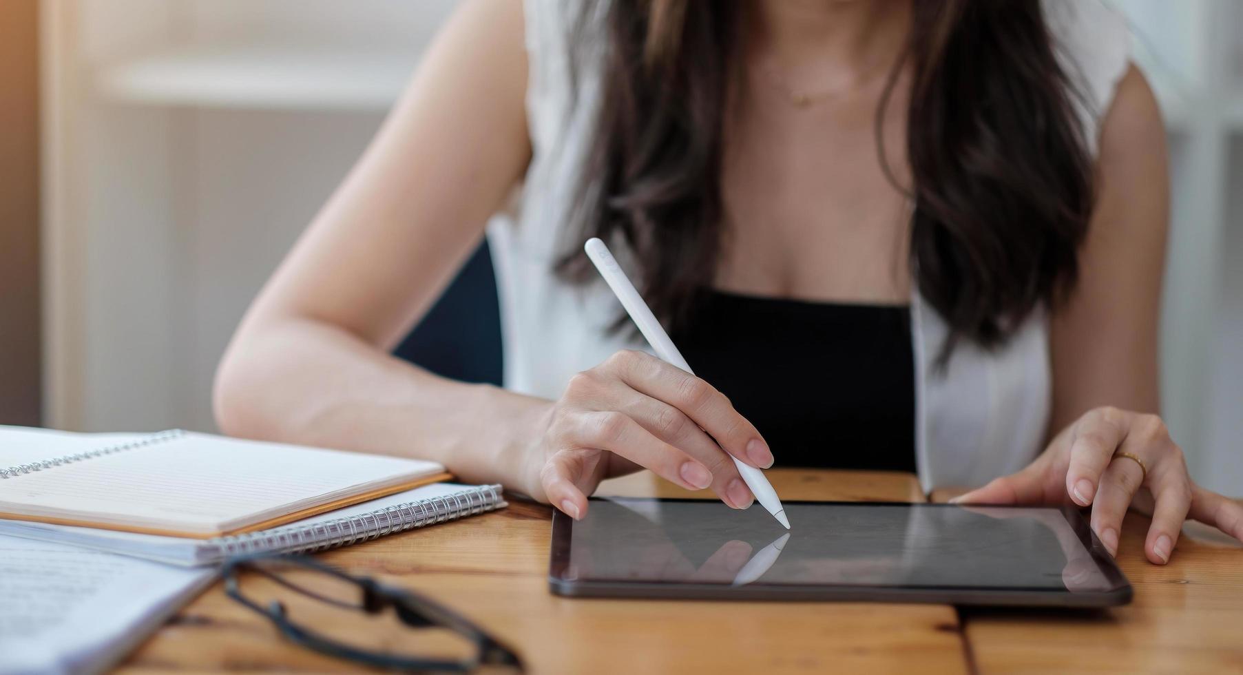 donna con tavoletta digitale e penna stilo sulla scrivania dell'ufficio foto