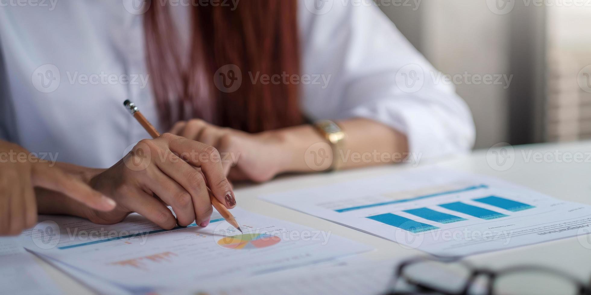 primo piano dell'uomo d'affari che controlla i grafici finanziari che mostrano i risultati del loro lavoro di squadra di successo in ufficio. foto