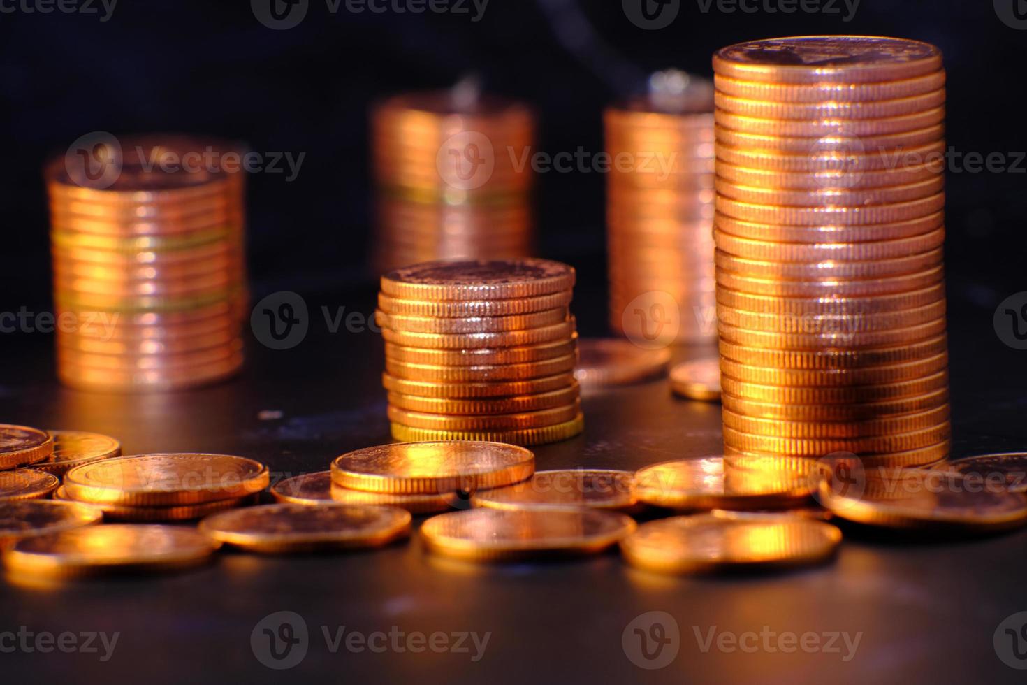 pila di monete su sfondo nero foto
