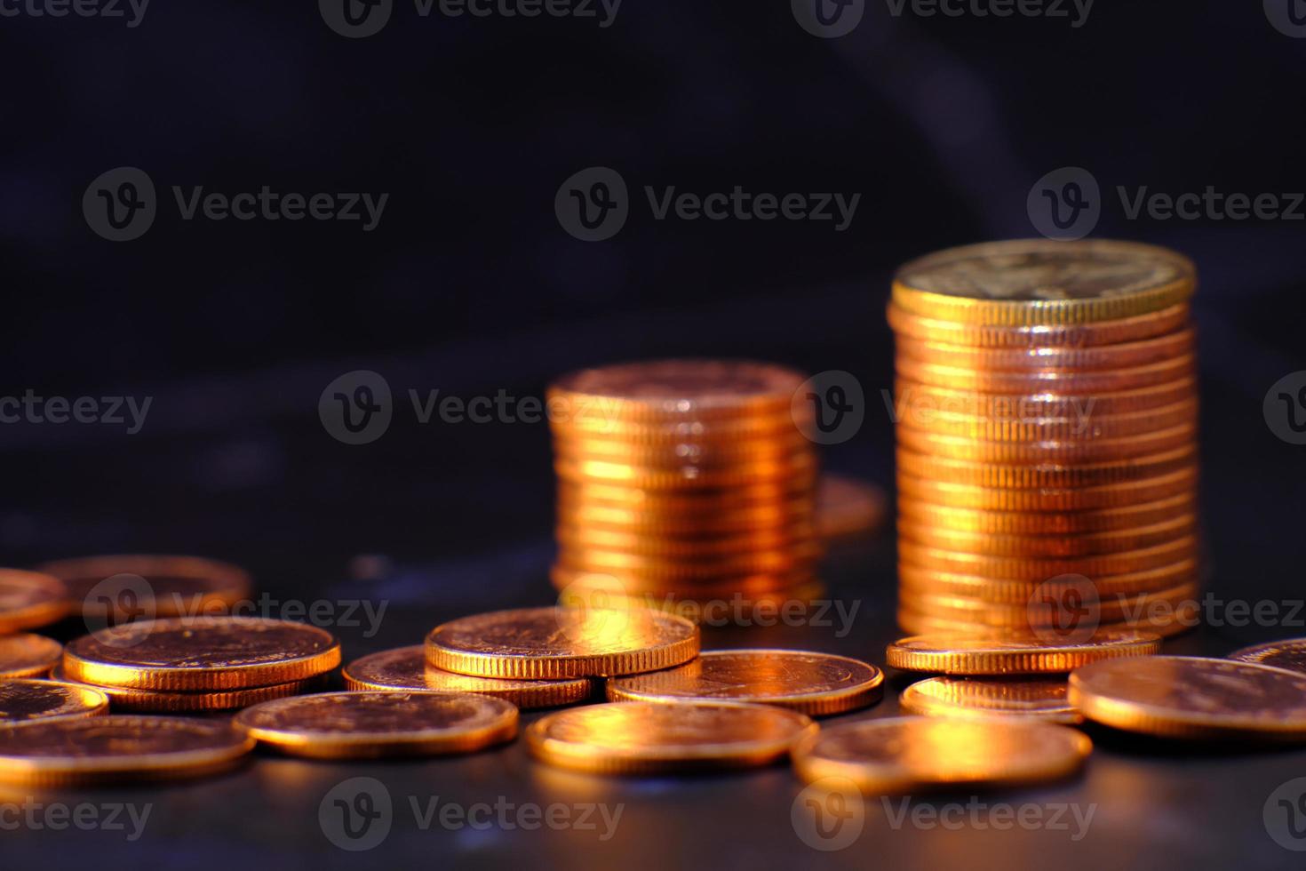 pila di monete su sfondo nero foto