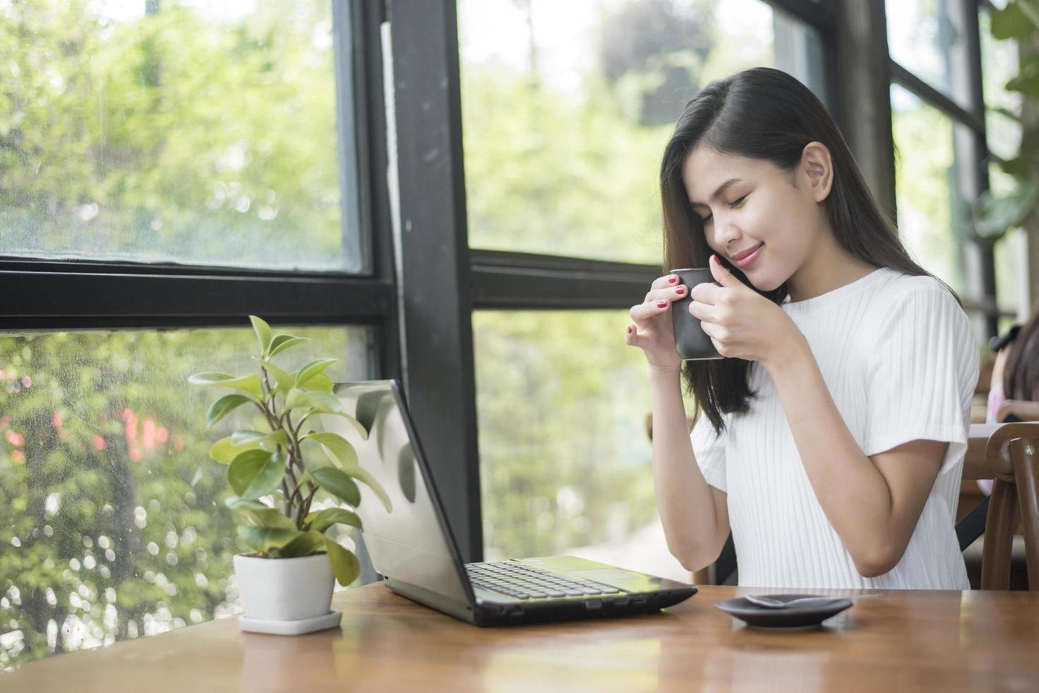 bella ragazza d'affari che lavora con tablet, smartphone e beve caffè nella caffetteria foto