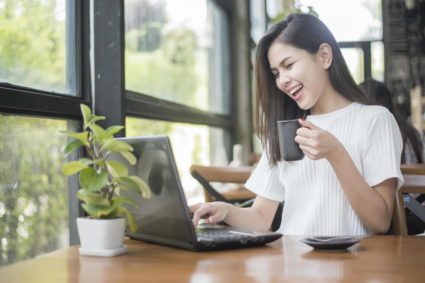 bella ragazza d'affari che lavora con tablet, smartphone e beve caffè nella caffetteria foto