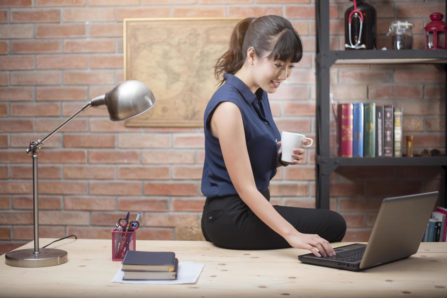 la bella donna sta lavorando in ufficio a casa foto