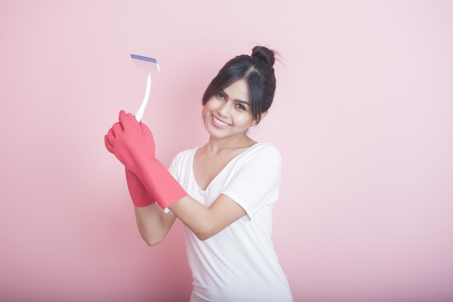 bella casalinga asiatica sorridente su sfondo rosa foto