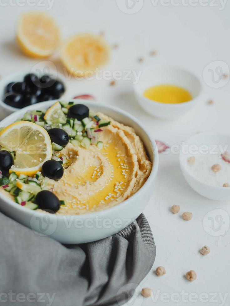 hummus di ceci, con olio d'oliva, olive, limone, aglio, semi di sesamo, cipolle e cetrioli. foto