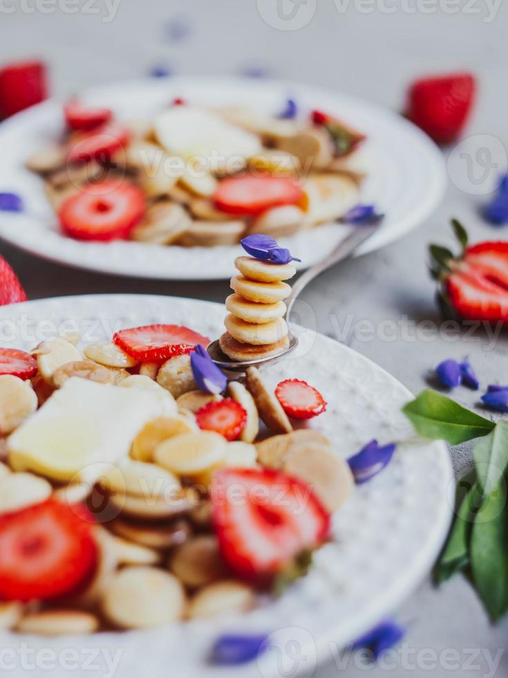 cereali per pancake, cibo alla moda. mini pancake ai cereali con burro, miele e fragole. foto