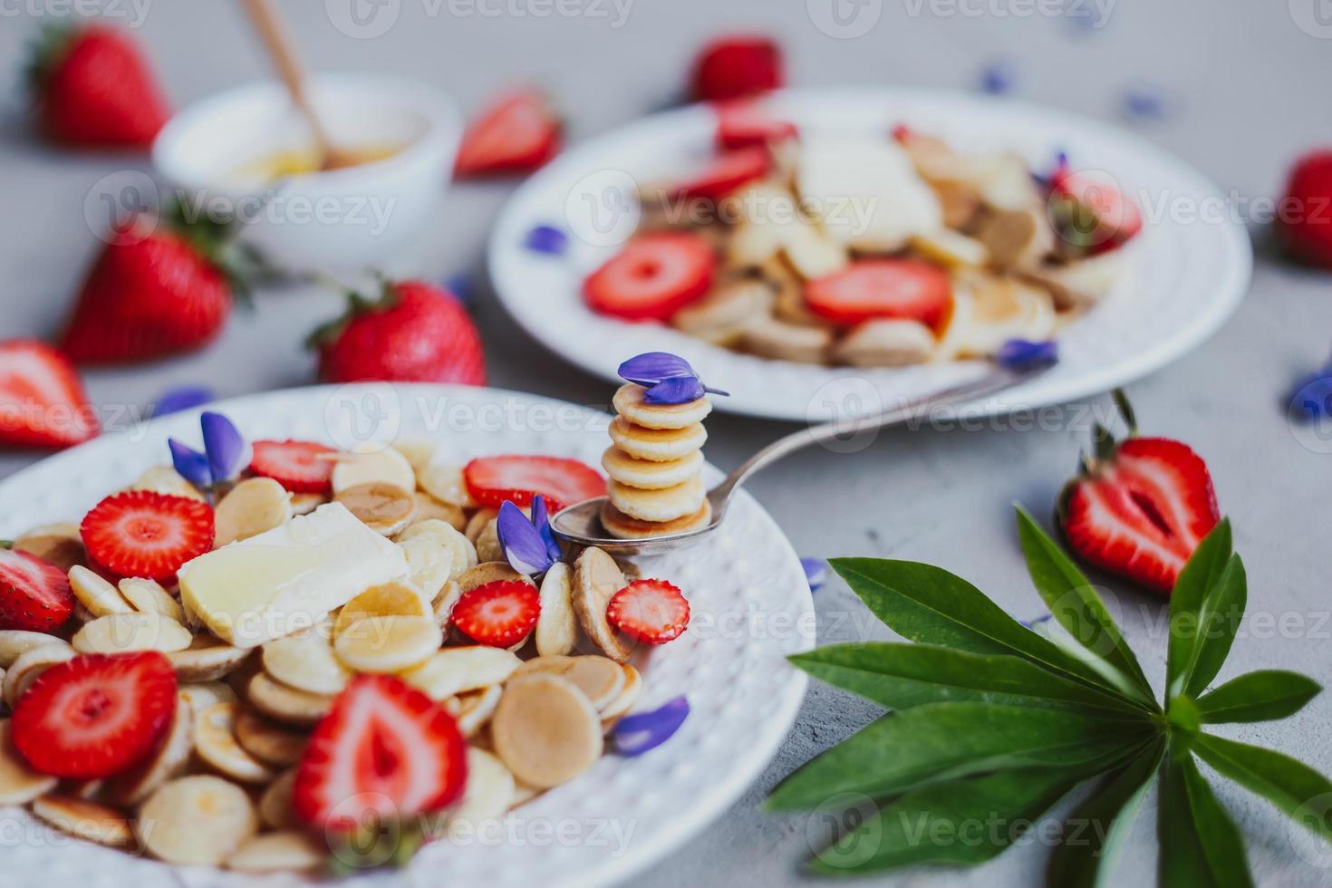 cereali per pancake, cibo alla moda. mini pancake ai cereali con burro, miele e fragole. foto