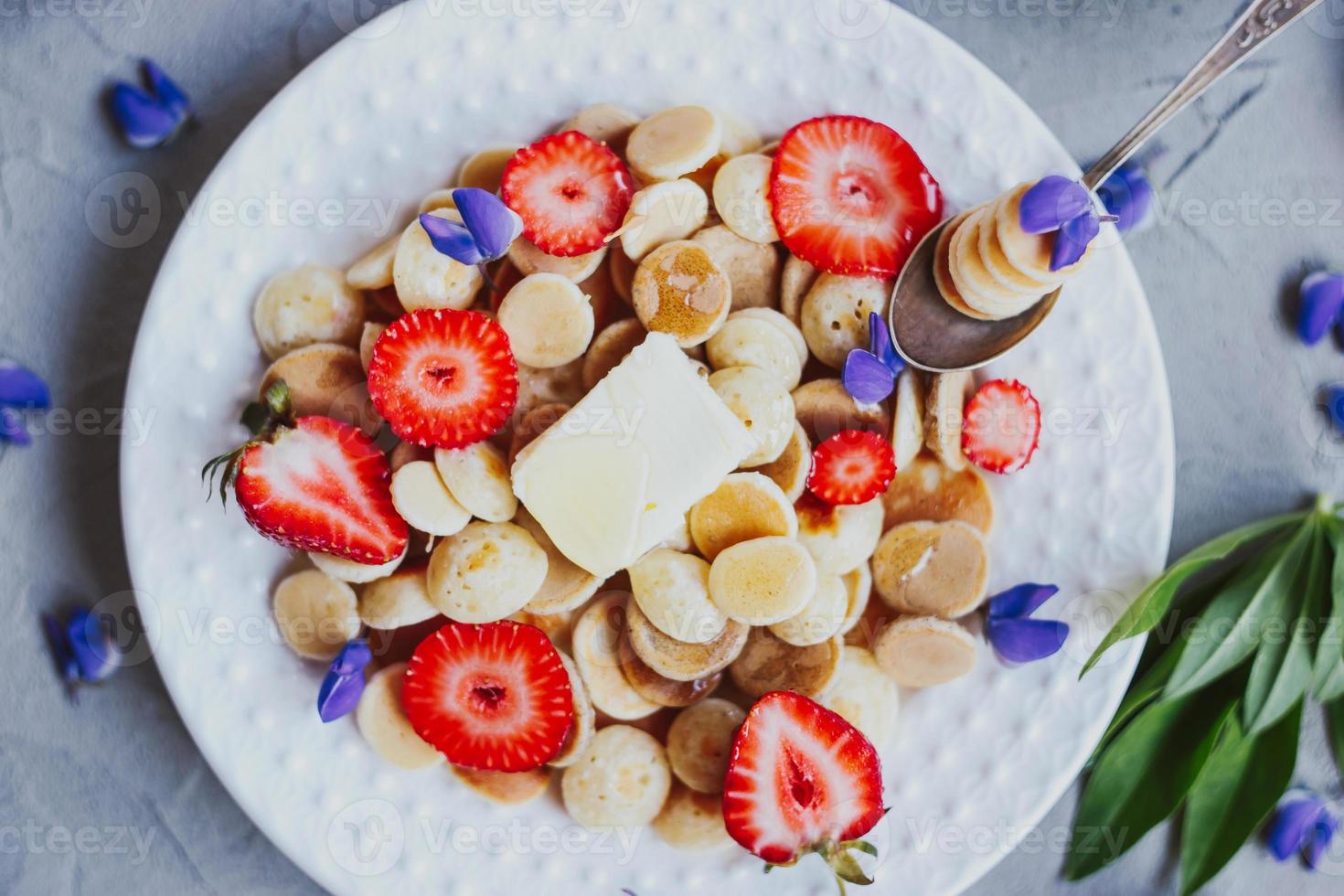 cereali per pancake, cibo alla moda. mini pancake ai cereali con burro, miele e fragole. foto