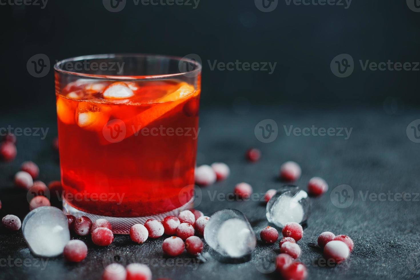 aperol spritz con ghiaccio e mirtilli rossi su sfondo nero. foto