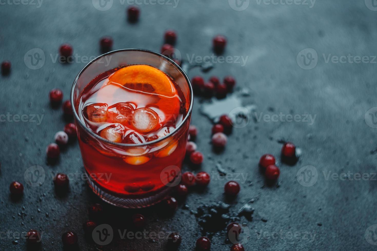 aperol spritz con ghiaccio e mirtilli rossi su sfondo nero. foto