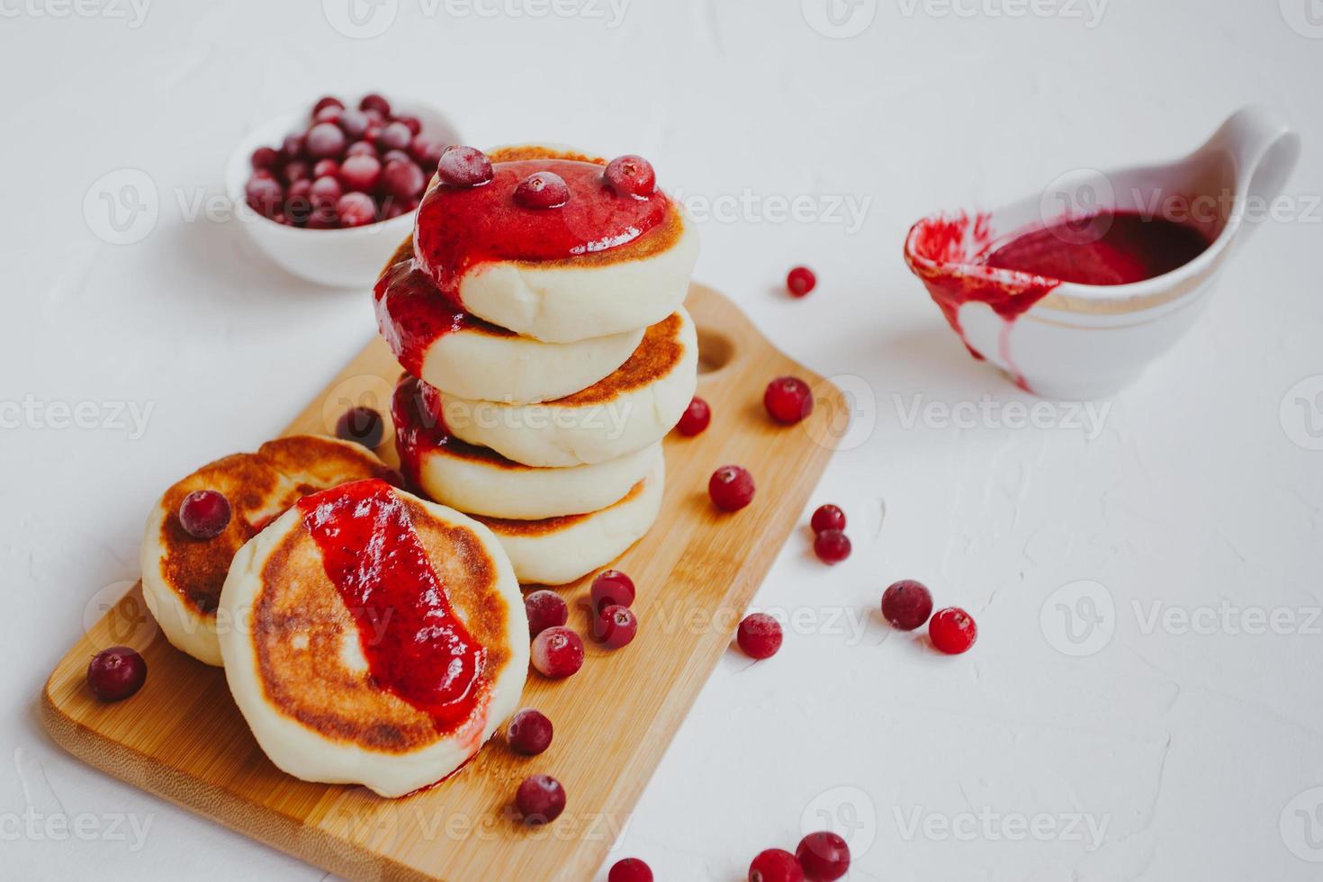 frittelle di ricotta fatte in casa o syrniki con marmellata di mirtilli rossi. foto