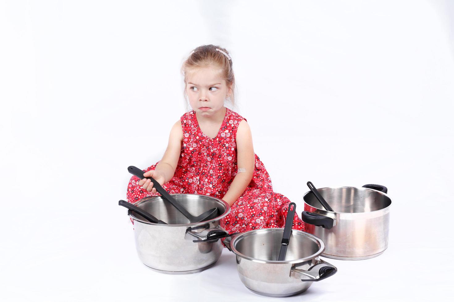 bambino che usa gli accessori della cucina divertendosi foto